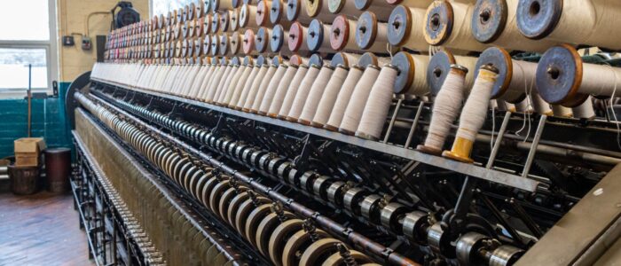 a big long machine on a hard wood floor of a large factory